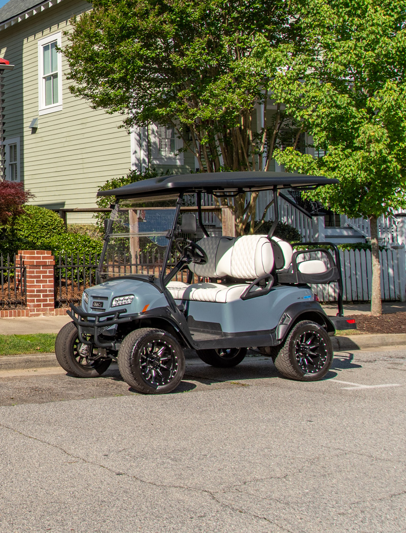 golf cart parked under a tree in the shade