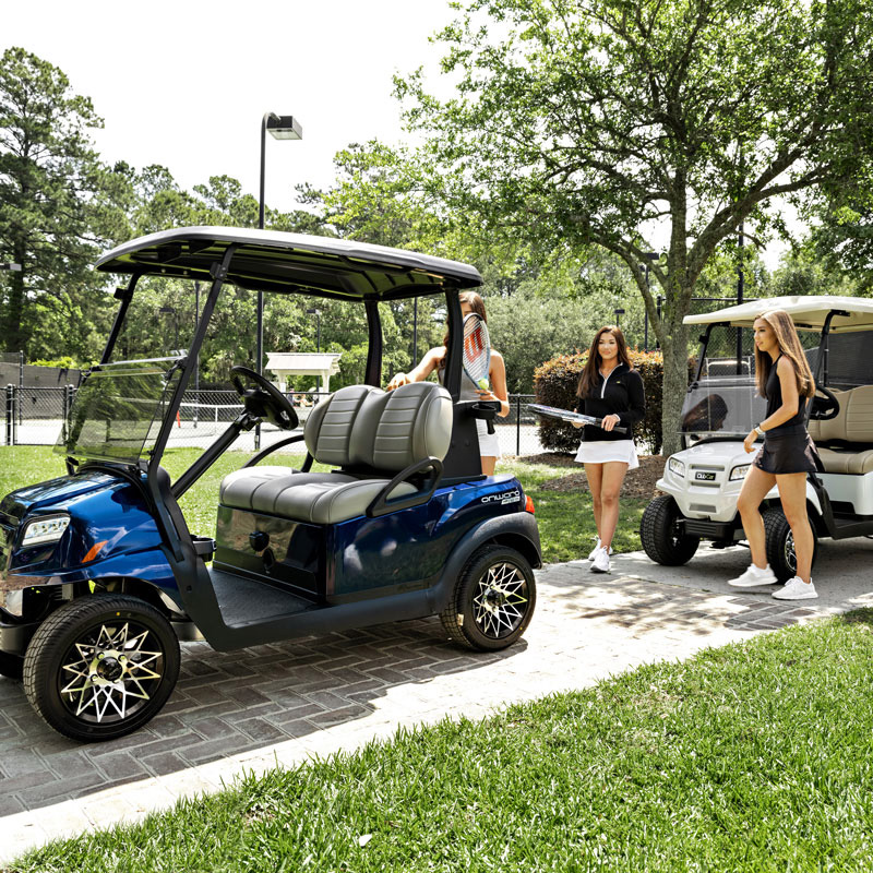 people standing with two golf carts